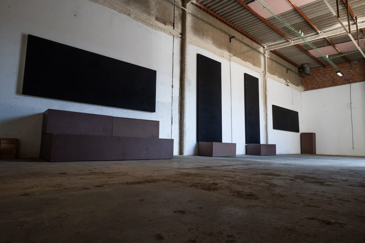 Taller diáfano en la primera planta, con paredes blancas y paneles negros